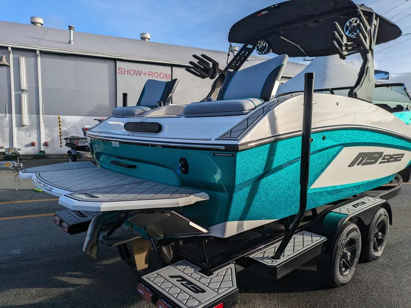 Slide: The Image of 2025 MB B52-23 Alpha boat in showroom, vibrant teal color, on a trailer. - 3