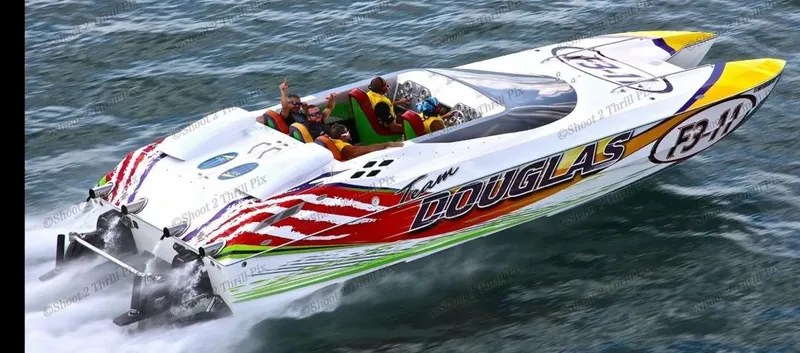Slide: The Image of 1999 Skater 32 powerboat speeding on water with vibrant graphics and passengers. - 1