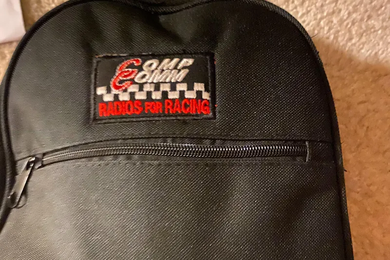 Slide: The Image of Black racing radio bag with "Radios for Racing" logo, featuring a zipper pocket. - 25