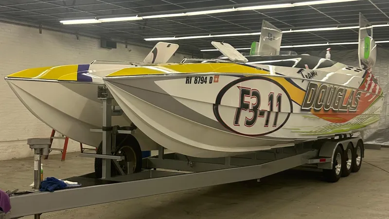 Slide: The Image of 1999 Skater 32 powerboat with vibrant graphics on a trailer in a garage. - 7