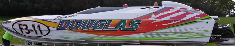 Slide: The Image of Colorful 1999 Skater 32 powerboat with "Douglas" branding and vibrant graphics. - 8
