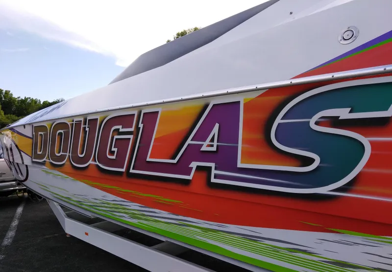 Slide: The Image of Colorful 1999 Skater 32 boat with "DOUGLAS" graphic on the side. - 9
