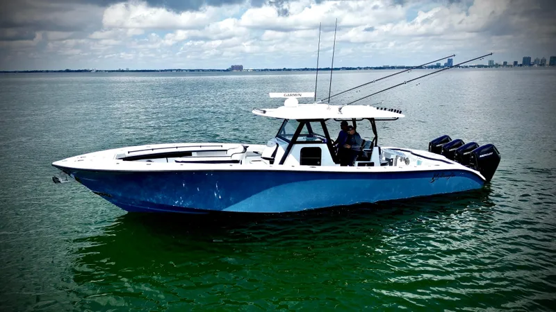 Slide: The Image of 2024 Yellowfin 39 Offshore boat on calm water with city skyline in background. - 11