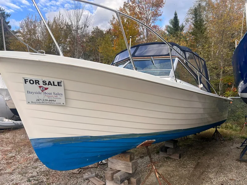 Slide: The Image of 1975 Lyman 26 Cruisette boat for sale, displayed outdoors with autumn trees. - 1
