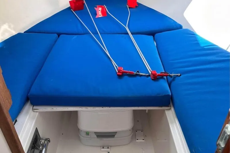 Slide: The Image of 1975 Lyman 26 Cruisette interior with blue cushions and storage compartment. - 12