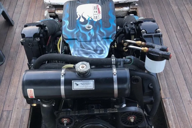 Slide: The Image of 1975 Lyman 26 Cruisette engine with custom blue flame design on wooden deck. - 13