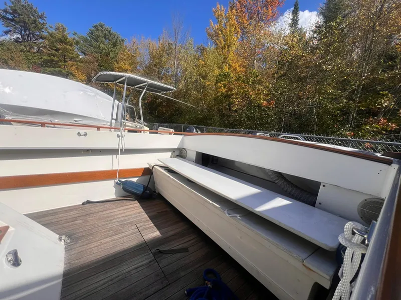 Slide: The Image of 1975 Lyman 26 Cruisette boat deck with autumn trees in the background. - 17