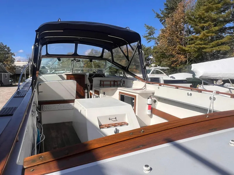 Slide: The Image of 1975 Lyman 26 Cruisette boat with open cockpit and canopy, docked outdoors. - 3