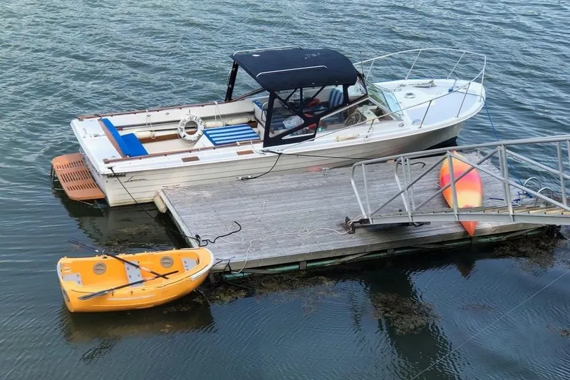 Slide: The Image of 1975 Lyman 26 Cruisette docked with kayak and paddleboard nearby. - 7