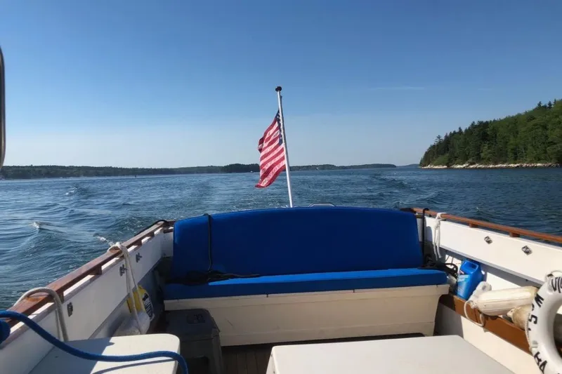 Slide: The Image of 1975 Lyman 26 Cruisette boat on open water with American flag. - 8