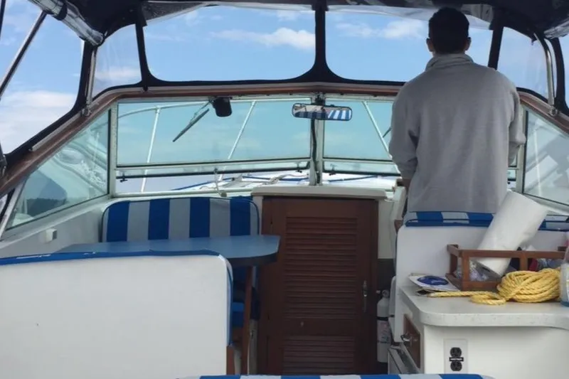 Slide: The Image of Interior of a 1975 Lyman 26 Cruisette boat with blue-striped seating. - 9
