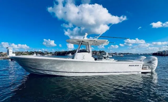 Slide: The Image of 2021 Regulator 34 boat on water under blue sky with clouds. - 0
