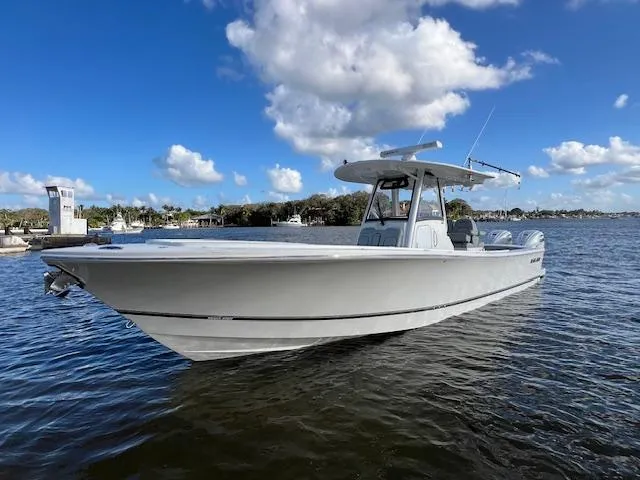 Slide: The Image of 2021 Regulator 34 boat on calm water under a blue sky with clouds. - 1