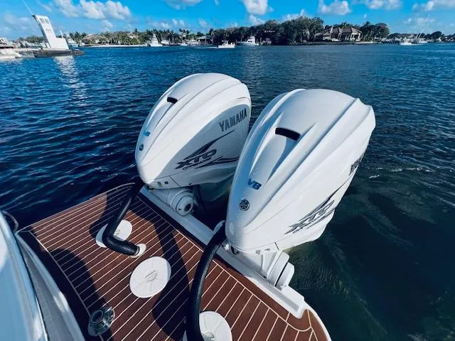 Slide: The Image of Twin Yamaha outboard engines on a 2021 Regulator 34 boat, docked on a sunny day. - 11