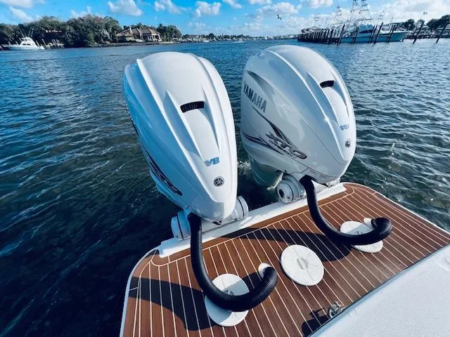 Slide: The Image of Twin Yamaha outboard engines on a 2021 Regulator 34 boat, docked on calm water. - 12