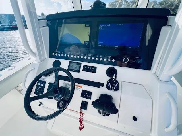 Slide: The Image of Control panel of 2021 Regulator 34 boat with steering wheel and navigation screens. - 16