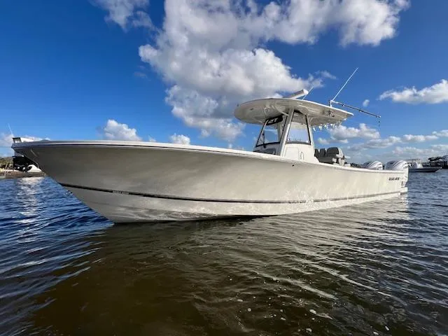 Slide: The Image of 2021 Regulator 34 boat on water under blue sky with clouds. - 2