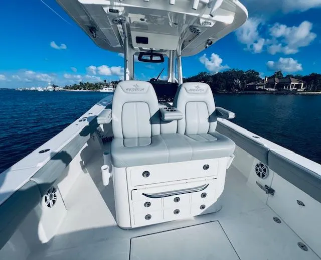 Slide: The Image of 2021 Regulator 34 boat interior with dual seats, ocean view, and clear blue sky. - 21