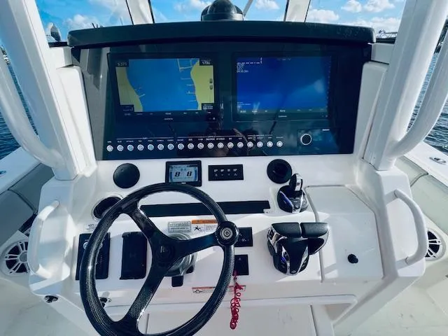Slide: The Image of 2021 Regulator 34 boat dashboard with dual navigation screens and steering wheel. - 23