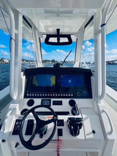 Slide: The Image of 2021 Regulator 34 boat cockpit with advanced navigation system and steering wheel. - 24