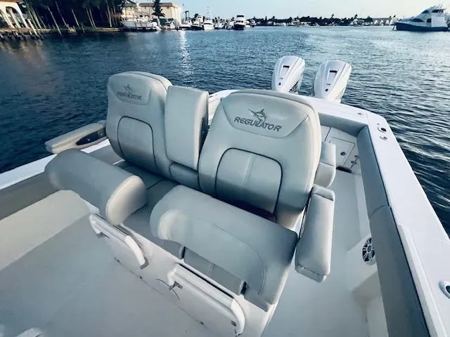 Slide: The Image of 2021 Regulator 34 boat with cushioned seating, docked by the water. - 32