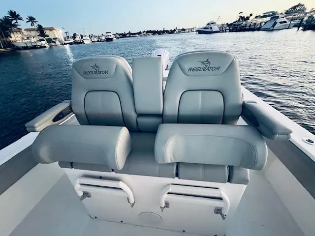 Slide: The Image of 2021 Regulator 34 boat seats overlooking marina with yachts and waterfront homes. - 33