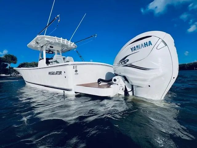 Slide: The Image of 2021 Regulator 34 boat with Yamaha engine on water, clear blue sky. - 8