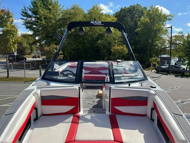 Slide: The Image of 2023 Axis A225 boat with red and white interior, parked near trees. - 3