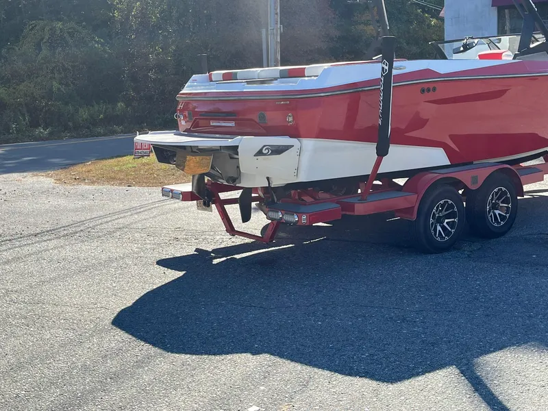 Slide: The Image of Red 2023 Axis A225 boat on trailer, parked on sunny road. - 7