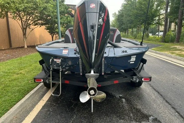 Slide: The Image of 2025 Ranger ALPHA 208 boat, rear view, parked on a street with lush greenery. - 3