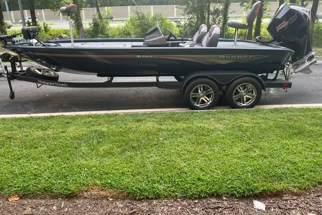 Slide: The Image of 2025 Ranger ALPHA 208 boat on trailer, parked on roadside with green grass. - 1