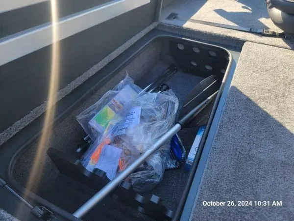 Slide: The Image of Secure storage compartment in a 2025 Ranger RT198P boat, containing fishing gear and accessories. - 6