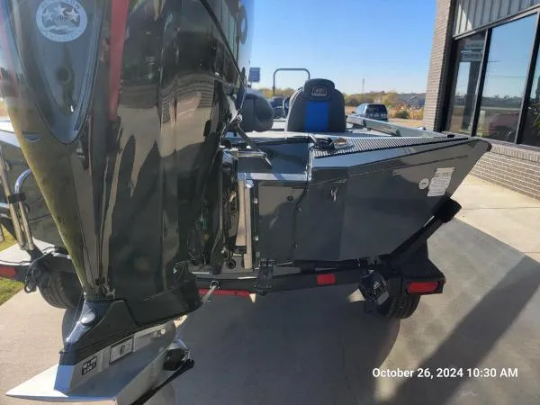 Slide: The Image of 2025 Ranger RT198P boat parked outside, rear view with motor and trailer. - 9