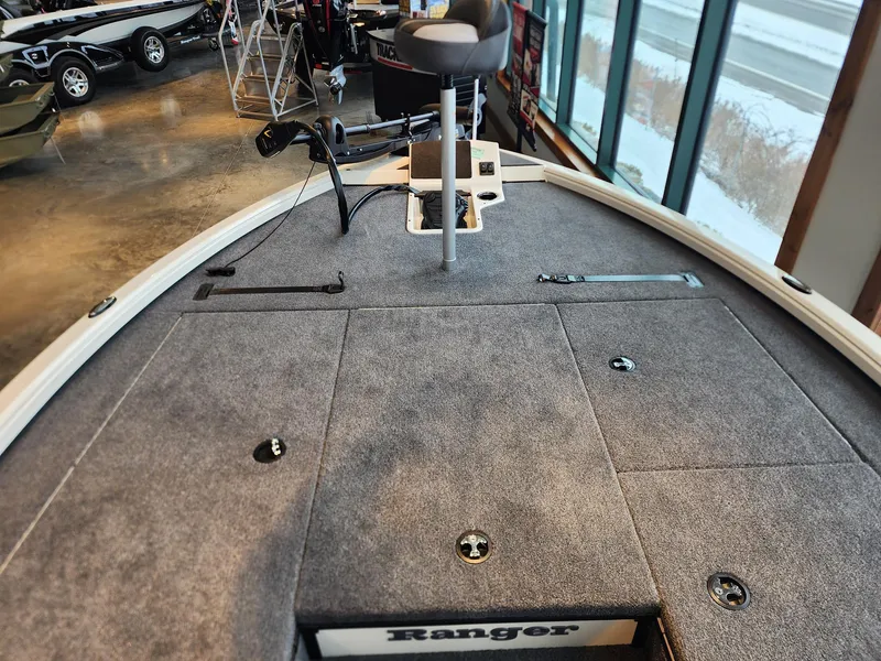 Slide: The Image of 2025 Ranger ALPHA 208 boat interior with carpeted deck and seating in showroom. - 5