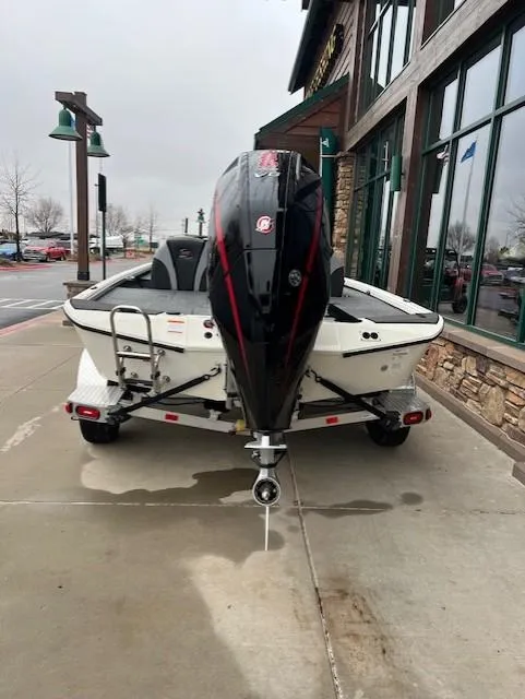 Slide: The Image of 2025 Ranger ALPHA 208 boat with powerful outboard motor, parked on a concrete surface. - 2