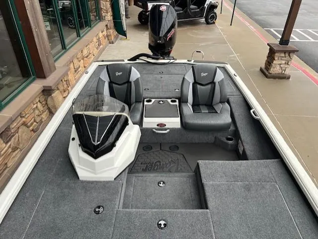 Slide: The Image of 2025 Ranger ALPHA 208 boat interior with dual seats and console, parked on pavement. - 6