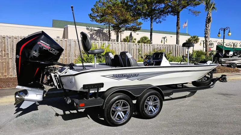 Slide: The Image of 2025 Ranger ALPHA 208 boat with dual axle trailer, parked outdoors. - 0