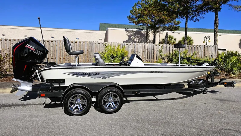 Slide: The Image of 2025 Ranger ALPHA 208 boat on trailer, parked outdoors, sunny day. - 1
