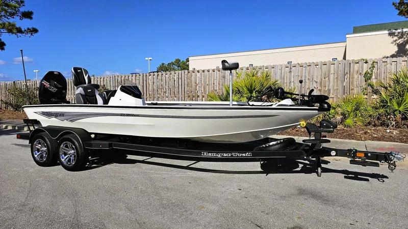Slide: The Image of 2025 Ranger ALPHA 208 boat on trailer, parked outdoors under clear blue sky. - 2