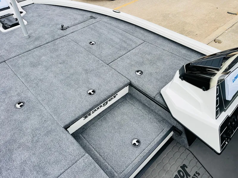 Slide: The Image of 2025 Ranger ALPHA 208 boat deck with gray carpet and storage compartments. - 19