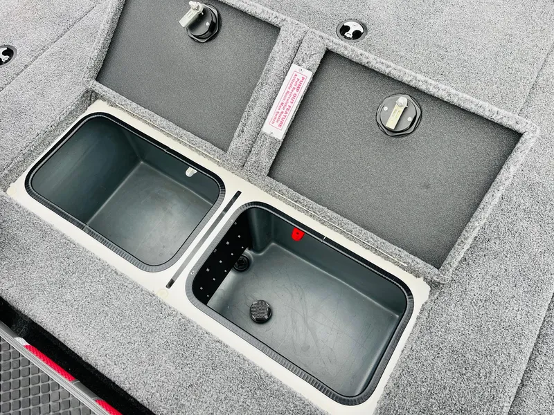 Slide: The Image of Ranger ALPHA 208 2025 boat storage compartments with secure latches and carpeted finish. - 39
