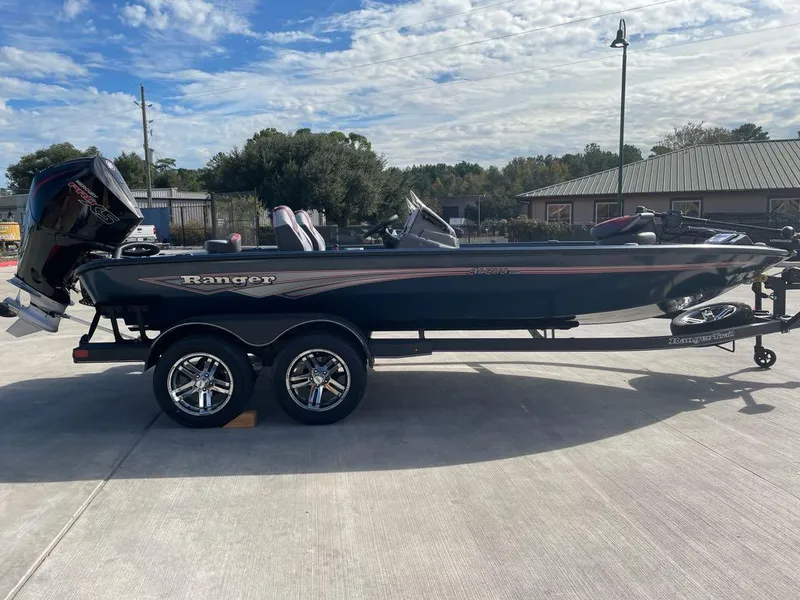 Slide: The Image of 2025 Ranger ALPHA 208 boat on trailer, parked outdoors under a partly cloudy sky. - 1