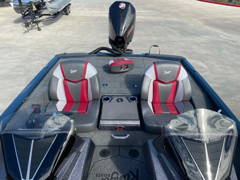 Slide: The Image of 2025 Ranger ALPHA 208 boat interior with red and gray seats, dual consoles, and motor. - 4
