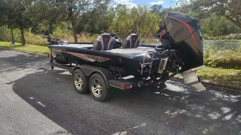 Slide: The Image of 2025 Ranger ALPHA 208 boat on trailer, parked on a sunny road. - 5