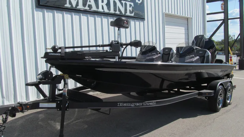 Slide: The Image of 2025 Ranger ALPHA 208 boat on trailer outside marine shop. - 2