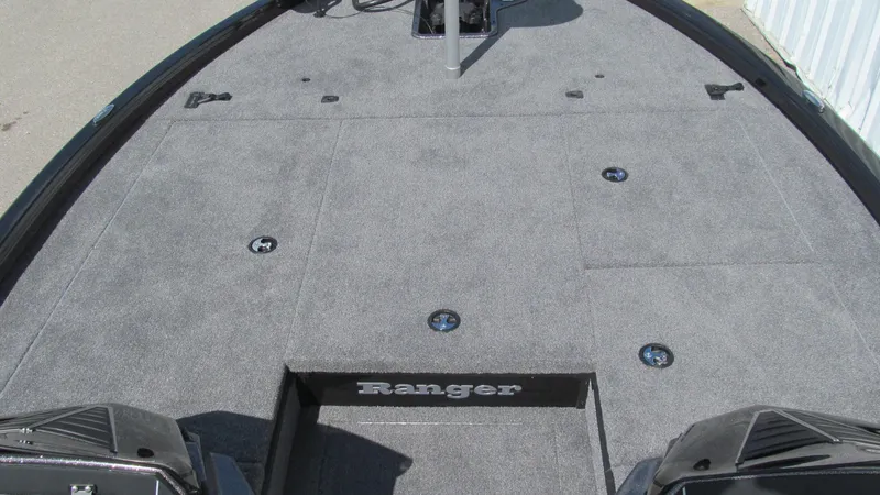 Slide: The Image of 2025 Ranger ALPHA 208 boat deck with gray carpet and storage compartments. - 9