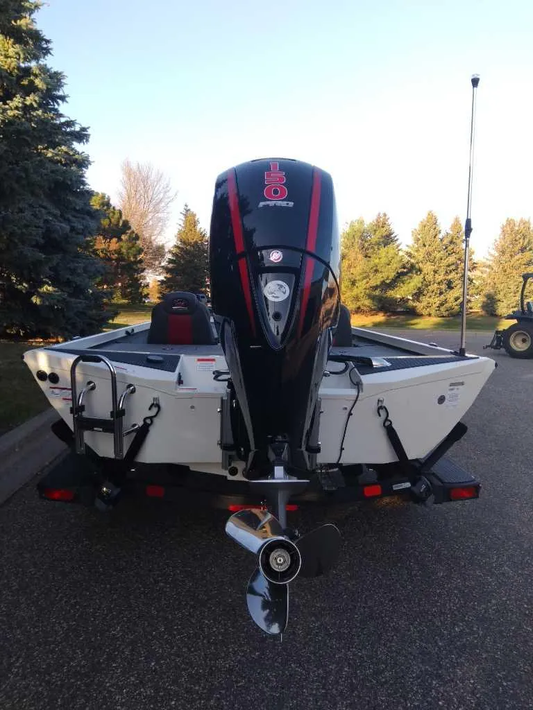 Slide: The Image of 2025 Ranger RT198P boat, rear view with motor, parked on a road. - 7