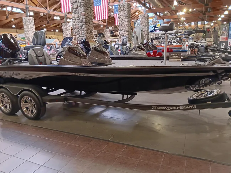 Slide: The Image of 2025 Ranger ALPHA 208 boat displayed indoors with American flags in the background. - 1