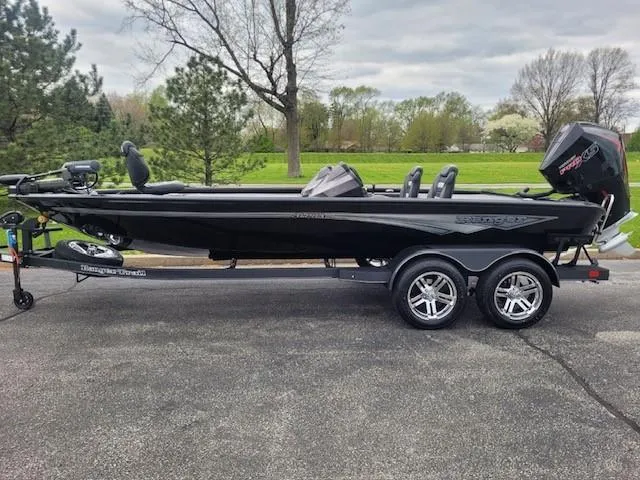 The Image of 2025 Ranger ALPHA 208 boat on trailer, parked outdoors, with trees in the background. - 0