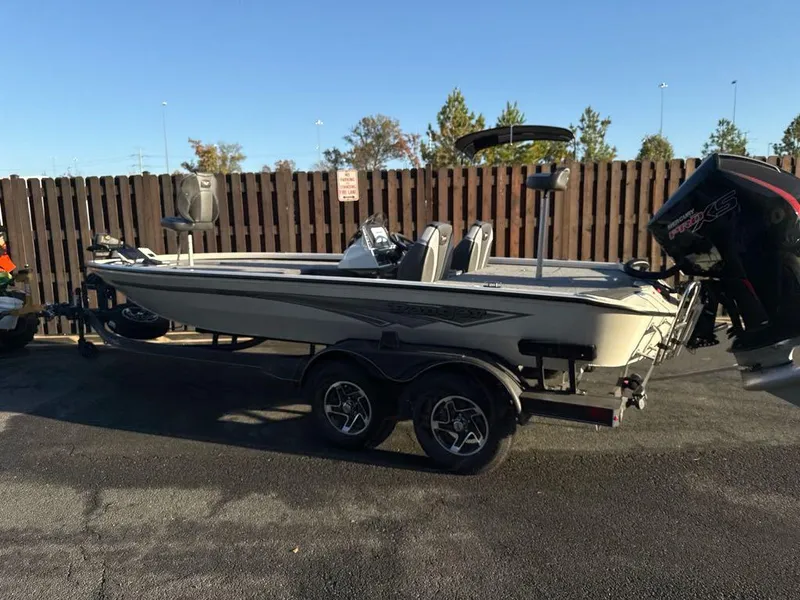 The Image of 2025 Ranger ALPHA 208 boat on trailer, parked outdoors, with outboard motor. - 0